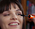 Betsy applying mascara to Sara